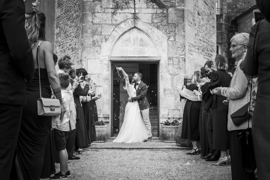 Shooting de mariage en noir et blanc, lors de la sortie d'église, dans un village entre Saintes et Cognac