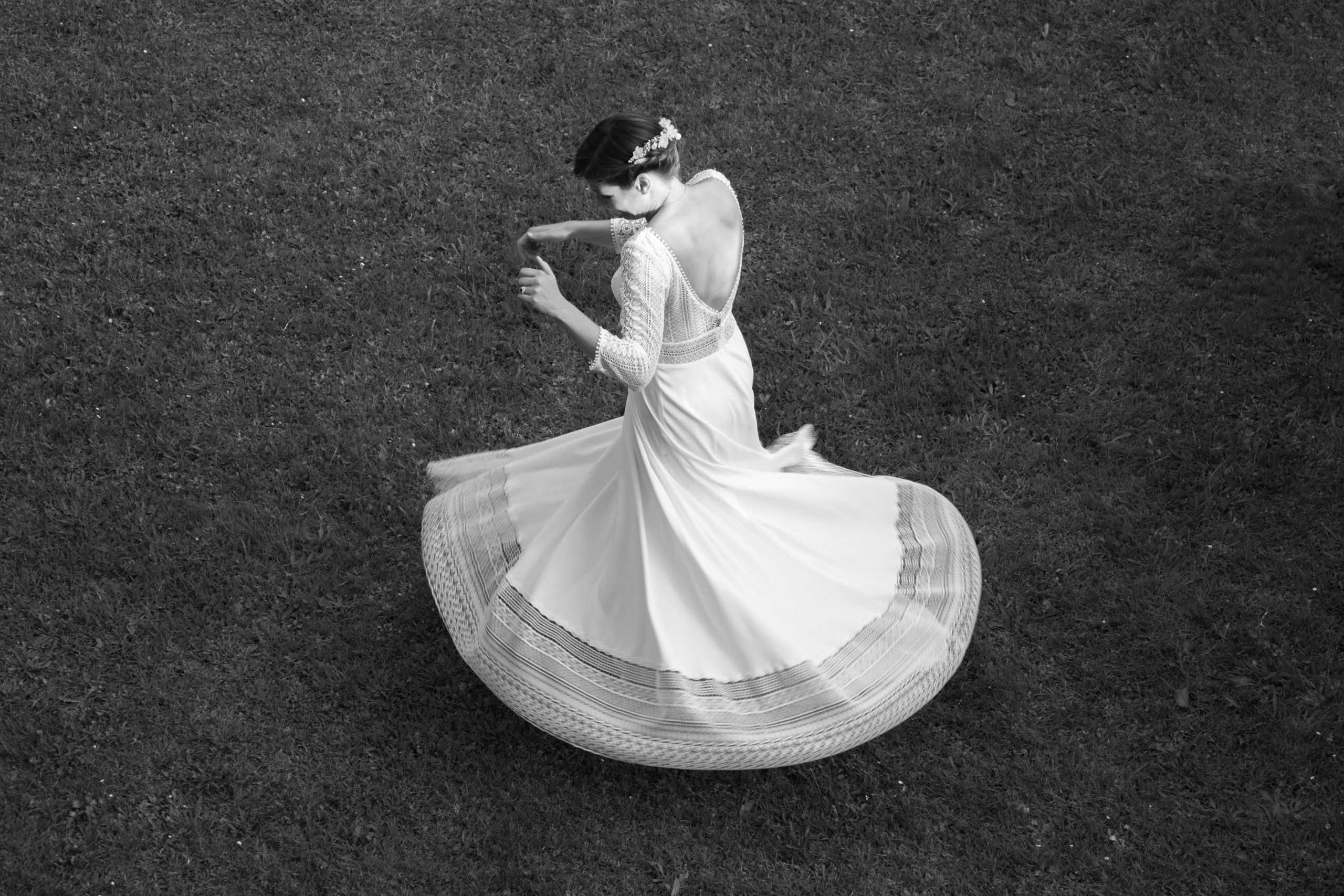 Photo en noir et blanc, d'une mariée dansant lors de son mariage