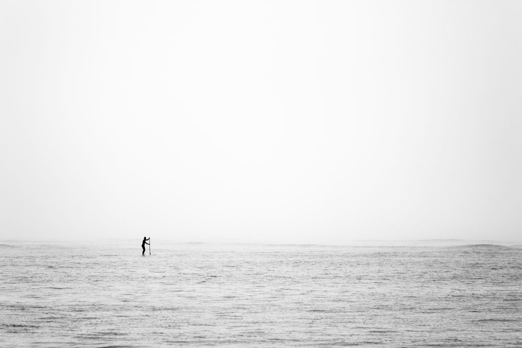 Cliché en noir et blanc d'un surfeur dans la brume, photographié par le photographe de Royan Shoot the land