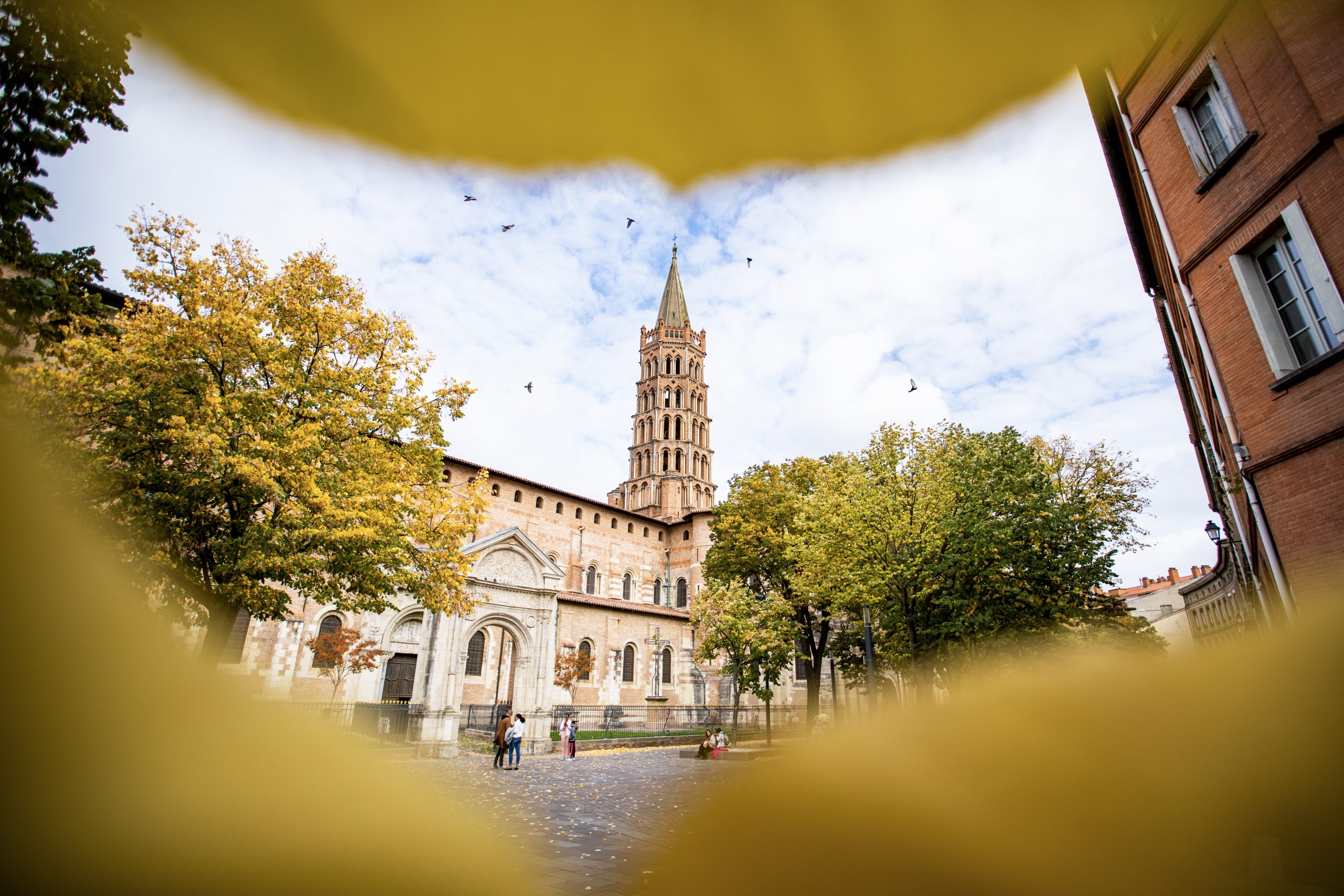 Basilique Saint-Sernin de Toulouse en automne, au milieu des feuilles jaunes